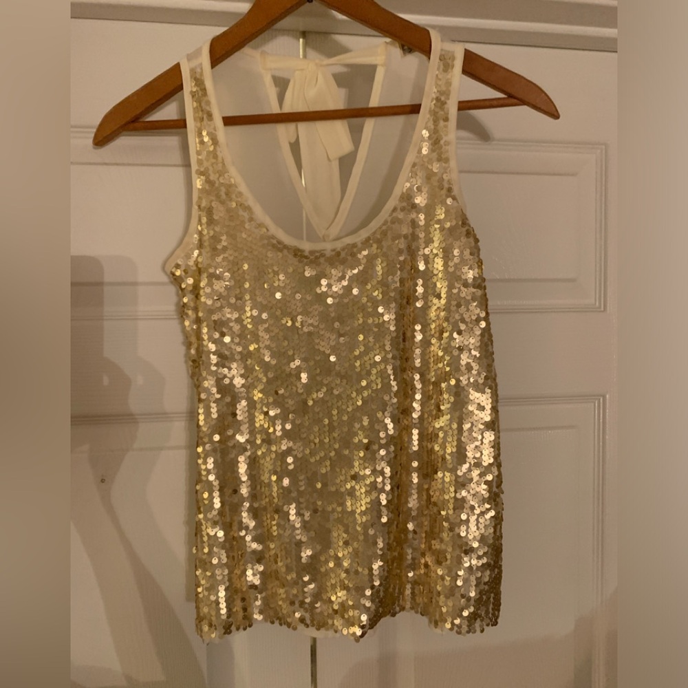 Sleeveless gold sequins top with sheer off white back. Sz S. Flares out slightly